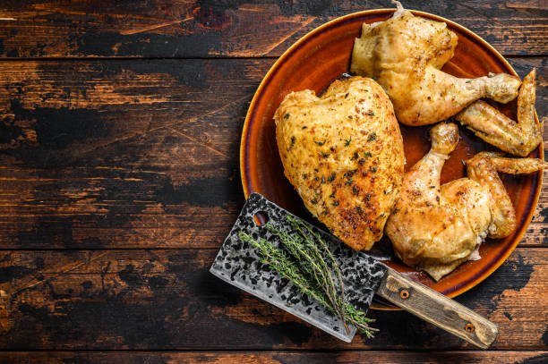 istock Butchered  baked chicken on wooden table.  Dark background. Top view. Copy space 1282533267