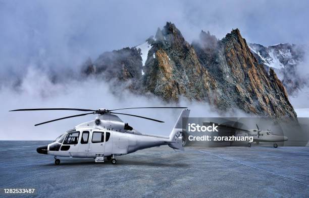 Helicopter And Propeller Airplane On Parking Apron At Snowcapped Mountains Backgrounds Stock Photo - Download Image Now