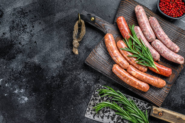 istock Assorted raw chorizo sausages on a wooden cutting board. Black background. Top view. Copy space 1282533590