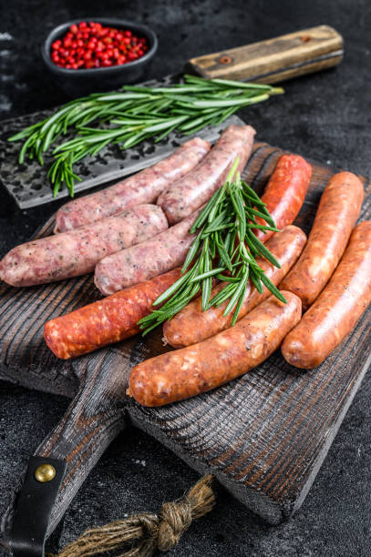 istock Assorted raw chorizo sausages on a wooden cutting board. Black background. Top view 1282533601