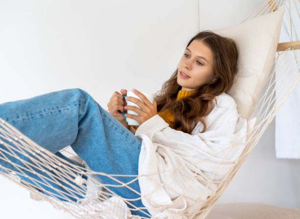 Cup of tea or coffee. Woman drinking hot beverage and enjoying morning, Cup of tea or coffee. Woman drinking hot beverage and enjoying morning, sitting on hammock and dreaming, relaxed mood. doing nothing stock pictures, royalty-free photos & images