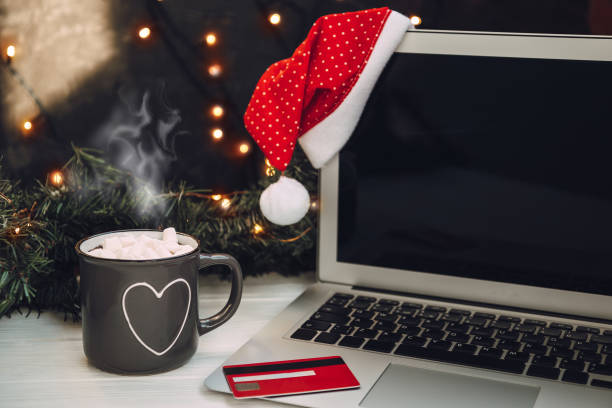 portátil, taza de cacao caliente y tarjeta de crédito - nuevo año concepto de compras en línea - holiday shopping fotografías e imágenes de stock