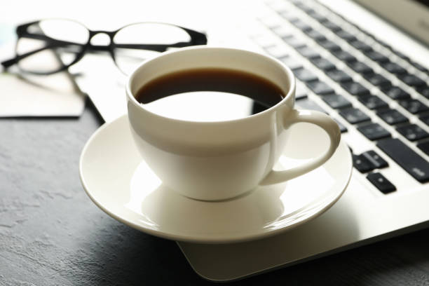 istock Laptop, glasses and cup of coffee on black table 1282538670