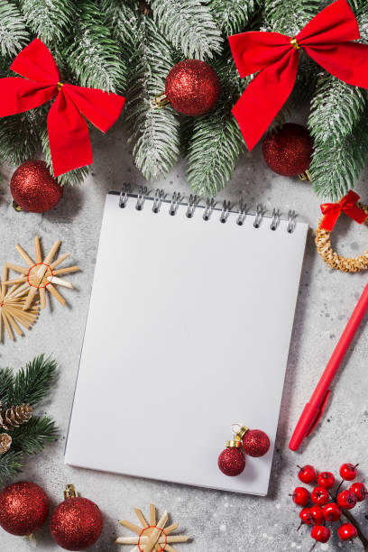 istock Christmas or New year holiday background with an open blank Notepad, fir branches and traditional Christmas decorations. A checklist or a letter to Santa. Christmas business greeting card. Copyspace 1282539709