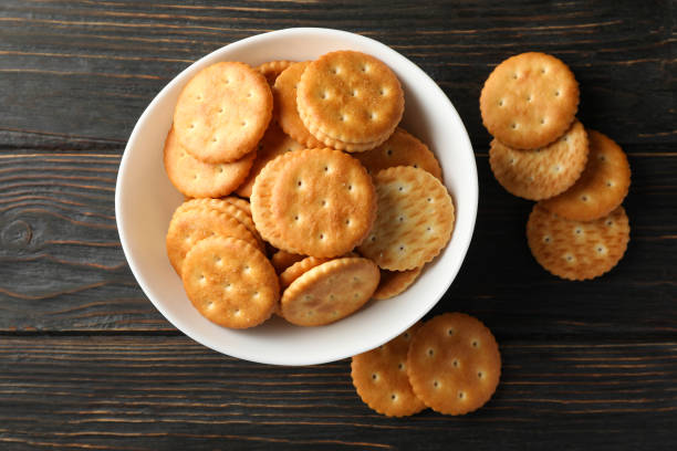 istock Bowl with tasty cracker biscuits on wooden background 1282539822