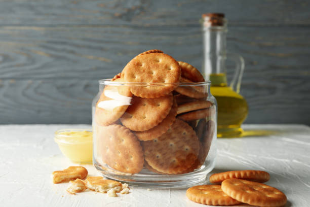istock Glass jar with crackers, sauce and oil on white table 1282540046