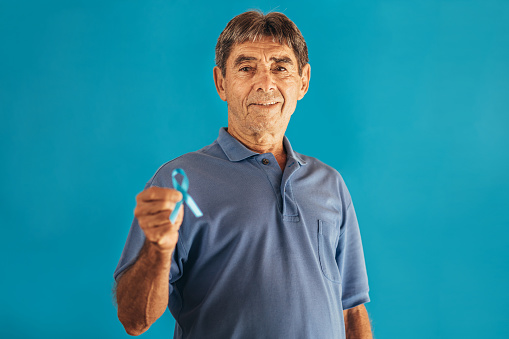 Conciencia sobre el cáncer de próstata. Hombre con cinta azul claro para apoyar a las personas que viven y enfermedades. Concepto del Día Mundial de la Salud y el Cáncer de los Hombres photo