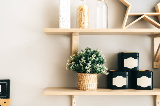 istock Grocery and kitchenware on the wooden shelves in modern bright kitchen. 1282541170