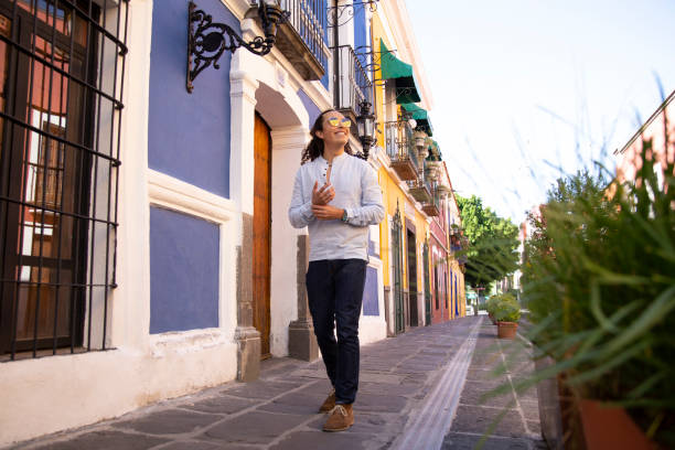 человек, идущего по красочной колониальной улице пуэбла, мексика - fashion street style clothing casual стоковые фото и изображения