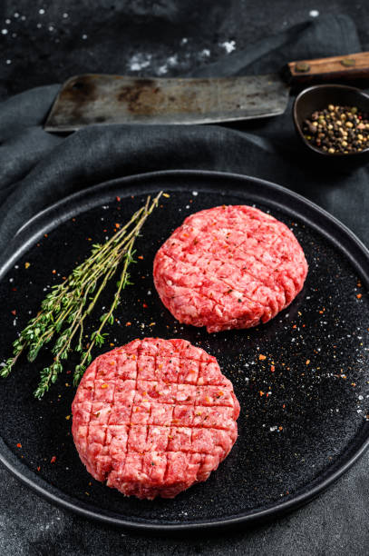 istock The ground beef patties, minced meat cutlets. Black background. Top view 1282546440
