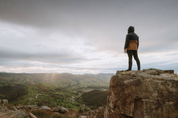istock Man standing on top of a mountain at sunset 1282547700