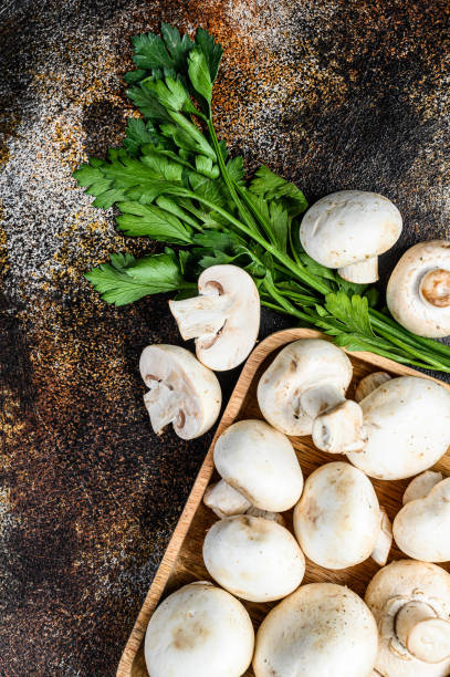 istock mushroom champignon in a bamboo bowl. Dark background. Top view 1282547794