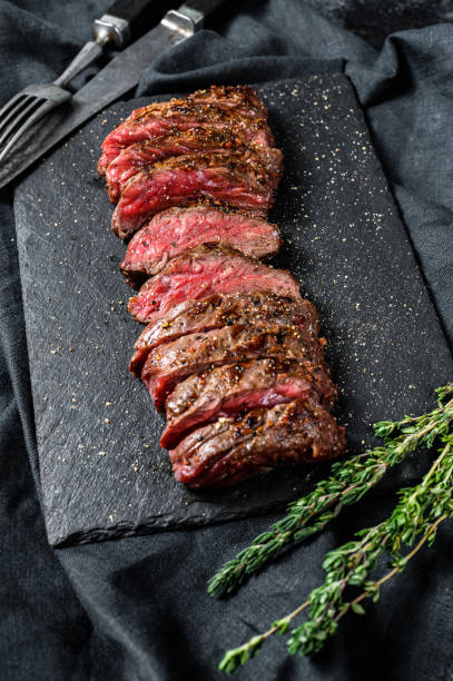 istock Grilled roasting rare sliced top blade, Denver steak. Marble meat beef. Black background. Top view 1282548145
