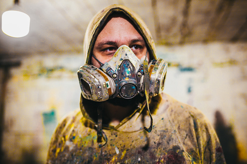 An artist with a crazy look and a gas mask