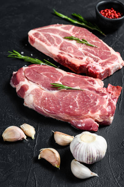 istock Fresh pork steak. Marbled meat. Black background. Top view 1282548175