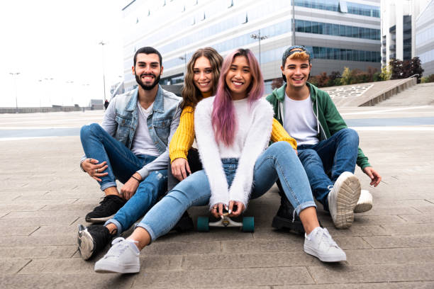 istock happy group of friend sitting on a skateboard. 1282548252