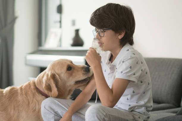 istock Sick boy making inhalation with her dog at home. 1282549157