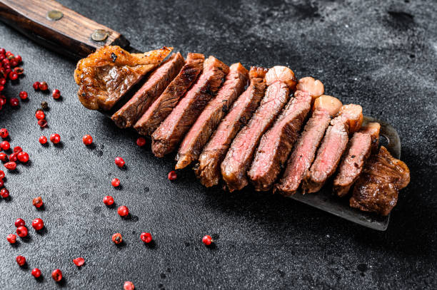 Grilled marbled beef steak. Black background. Top view Grilled marbled beef steak. Black background. Top view. barbecue beef stock pictures, royalty-free photos & images