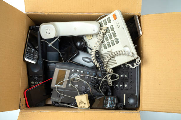 old desk phones, cordless phone, cell phones and smartphones in a cardboard box - scrap metal audio imagens e fotografias de stock