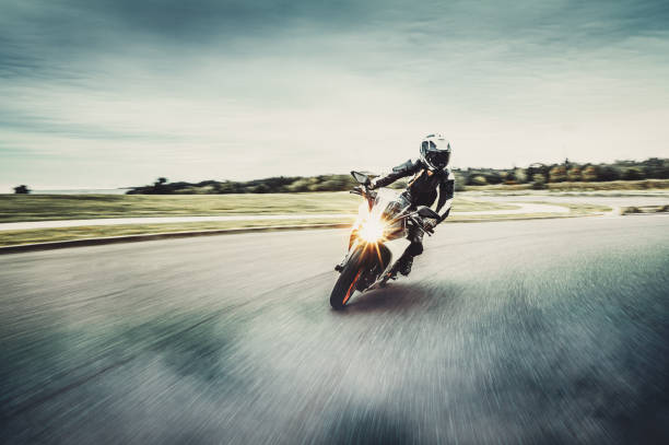 Motorcycle in blurred motion Woman drives on a motorcycle on a country road motorcycle stock pictures, royalty-free photos & images