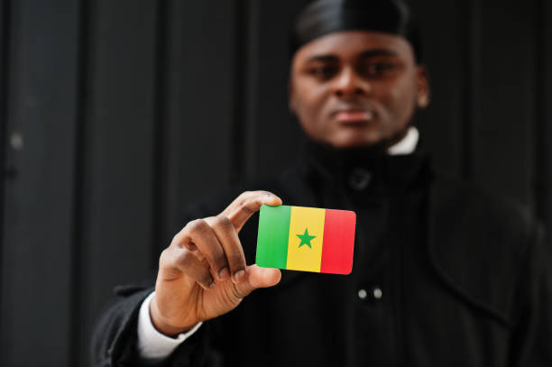 afrykanin nosić czarny durag posiadają flagę senegalu pod ręką izolowane ciemne tło. - dakar region zdjęcia i obrazy z banku zdjęć