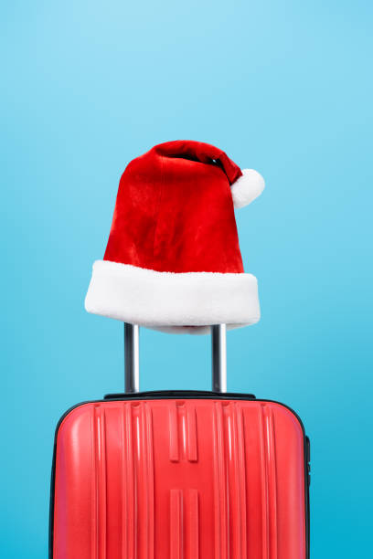 istock red santa hat on modern travel bag isolated on blue 1282557894