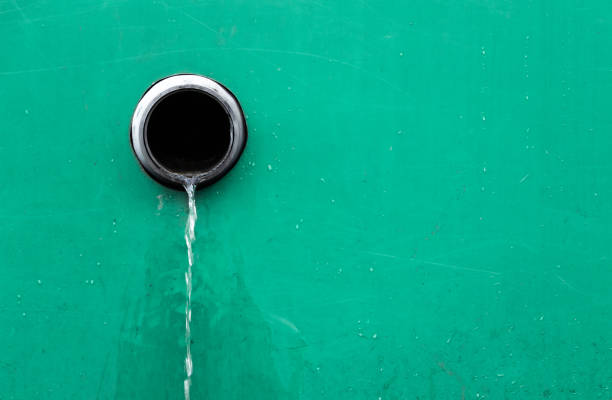 Sewer in the wall with flowing water after rain. Drain system