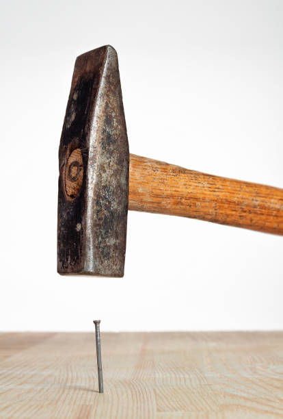 istock Hammer nail hit into a wooden plank 1282558425
