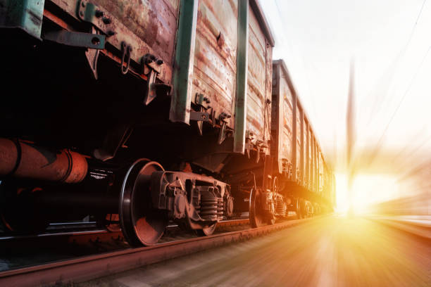 istock Freight train passing at sunset. Train carrying cargo under the rays of the setting sun. 1282559354