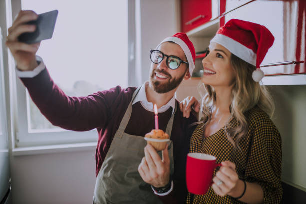 coppia che si diverte per natale o capodanno e si fa un selfie con lo smartphone - muffin blueberry muffin blueberry isolated foto e immagini stock