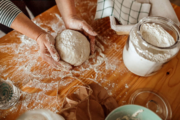 Woman's hands kneading sourdough Close-up of woman's hands kneading sourdough on the table yeast starter stock pictures, royalty-free photos & images
