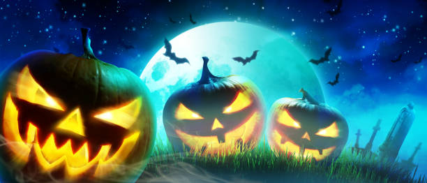 istock Halloween pumpkin face with burning fire inside in the graveyard. 1282560649
