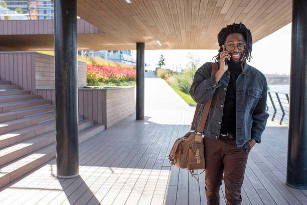 istock Smiling man talking on a mobile phone outdoors 1282561790