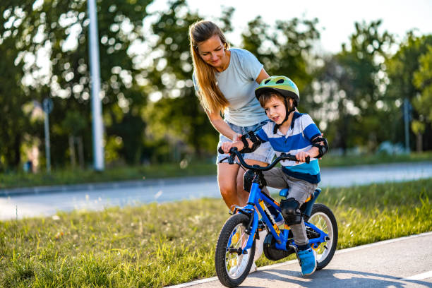 istock Boy learning to ride a bicycle with mother 1282562300