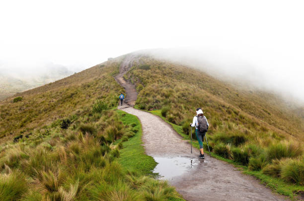 Two women hiking the Pichincha volcano ascent in the mist along the walking trail, Quito, Ecuador.