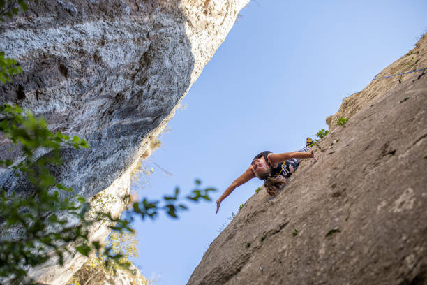 istock Woman hanging from the rope while rock climbing in nature 1282566703