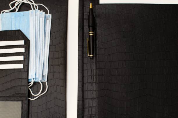 leather business folder with a set of essential antivirus masks leather business folder with a set of essential antivirus masks during pandemic leather care stock pictures, royalty-free photos & images
