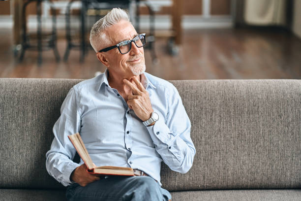 Happy adult man in glasses spending his weekend while reading