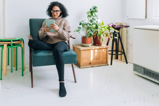 istock Working from Home: a Young Woman USing a Digital Tablet to Read/Watch Something 1282568702