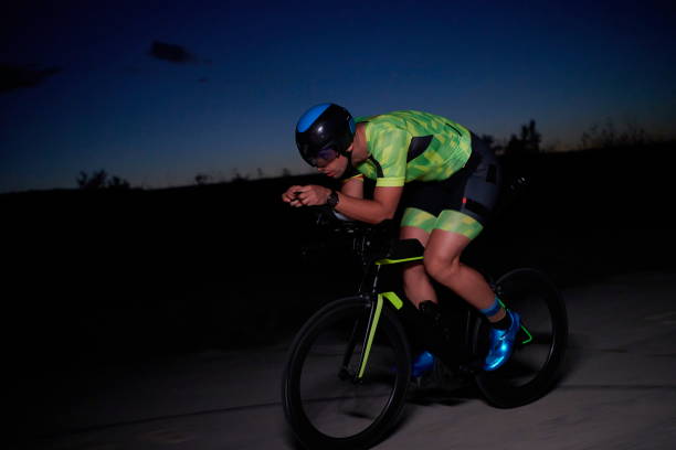 istock triathlon athlete riding bike fast  at night 1282574118