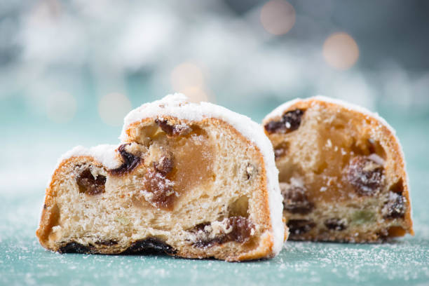 Christstollen, traditonal christmas cake with nuts, raisons, marzipan on a blue background, empty space for text