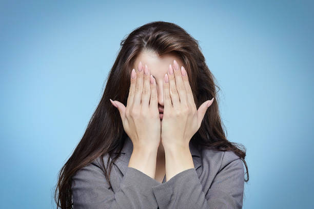 istock young girl covers her face with her hands 1282576601