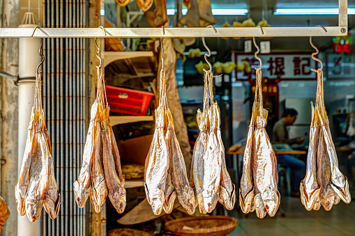 Lantau, Hong Kong - January 3, 2020: Dried fish hanging for sale on the streets of Tai O fishing village in Hong Kong