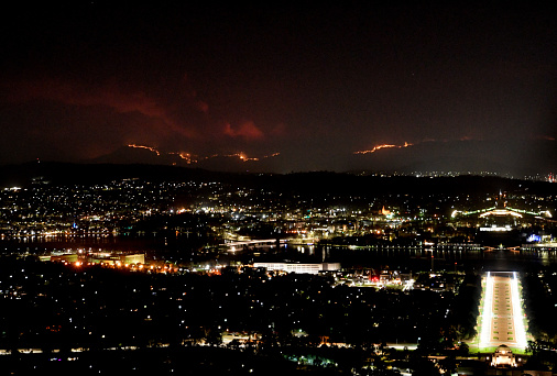 Canberra, Australia seen at night from above with bushfire in the distance