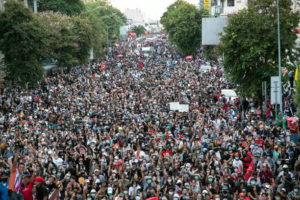 multitud de manifestantes marchan en bangkok, tailandia - protest fotografías e imágenes de stock