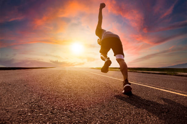 man running and sprinting on road with sunset background