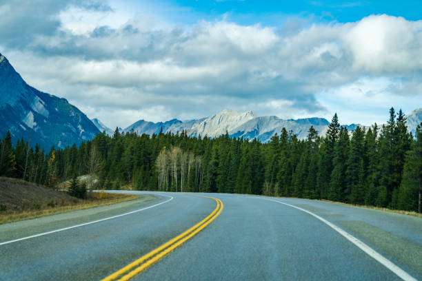 istock Rural road in the forest with mountains in the background. 1282587346