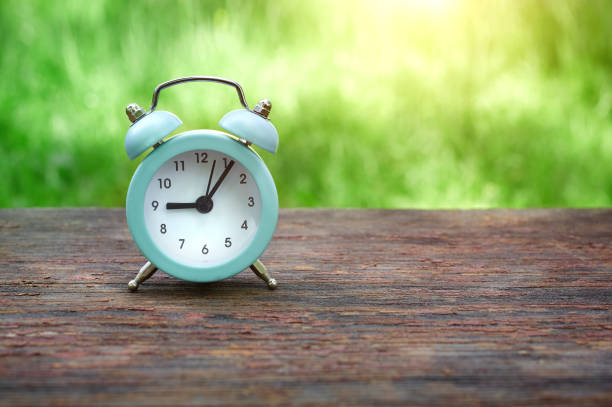 istock Summer time concept with alarm clock, summer meadow and grass 1282588340