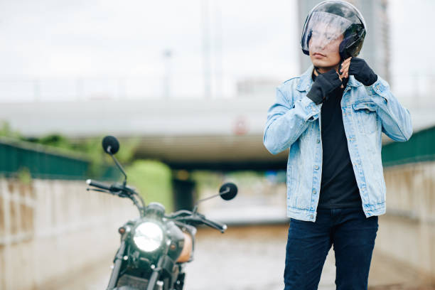 istock Man buckling motorcycle helmet 1282589454