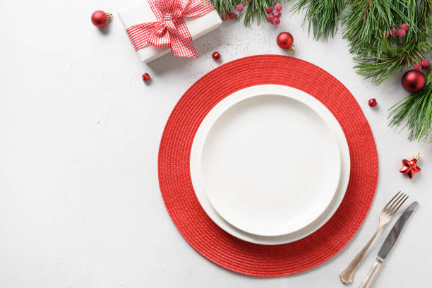 istock Christmas festive table setting with white and red holiday decorations on white table. 1282589640